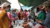 កម្មកររោងចក្រកាត់ដេរប្រភឹសឹស ខេមបូឌា ហ្គាមេន អិលធីឌី ក្នុងខេត្តកណ្តាល ឈរទិញបាយ និងម្ហូបក្នុងម៉ោងសម្រាក នាថ្ងៃទី២០ ខែមីនា ឆ្នាំ២០២០។ (កាន់ វិច្ឆិកា/VOA Khmer)