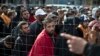 People wait in line to board buses organized by the Austrian government in Hegyeshalom, Hungary, Sunday, Sept. 6, 2015. 