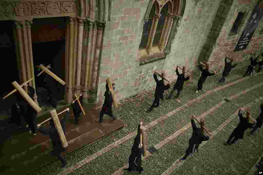 Masked penitents hold their crosses as they arrive at Roncesvalles Church during spring "Romeria Cruceros de Arce", in northern Spain.