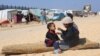 Displaced Palestinian girl, who fled her house due to Israeli strikes, feeds her brother at a tent camp, near the border with Egypt, in Rafah in the southern Gaza Strip, Feb. 25, 2024. 