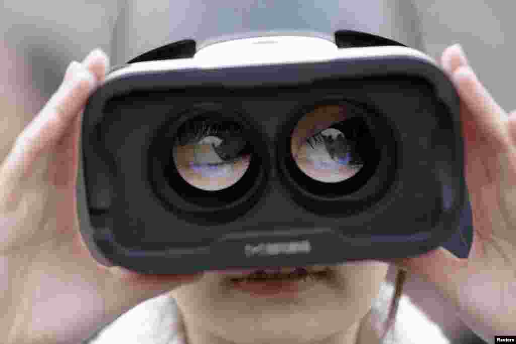 A girl wears a virtual reality headset outside the Great Hall of the People in Beijing after the opening session of the Chinese People&#39;s Political Consultative Conference (CPPCC) in Beijing.