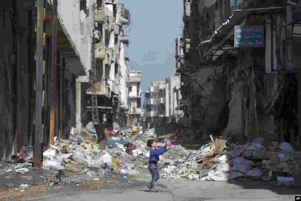 A Syrian boy plays between destroyed buildings in the old city of Homs, Syria. The U.N. Security Council is expected to vote Friday afternoon on a draft resolution endorsing the &quot;cessation of hostilities&quot; in Syria that is set to start at midnight local time.