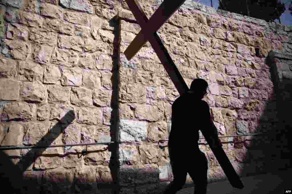 A Catholic pilgrim carries a wooden cross along the Via Dolorosa (Way of Suffering) in Jerusalem&rsquo;s Old City during the Good Friday procession. Many Christian pilgrims took part in processions along the route where according to tradition Jesus Christ carried the cross during his last days.