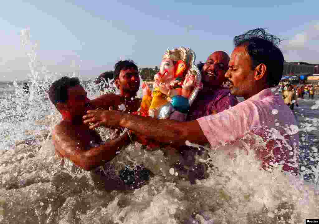 Warga India membawa patung Dewa Ganesha, dewa kemakmuran, ke laut Arabia pada hari kedua festival keagamaan Chaturthi Ganesha di Mumbai, India.