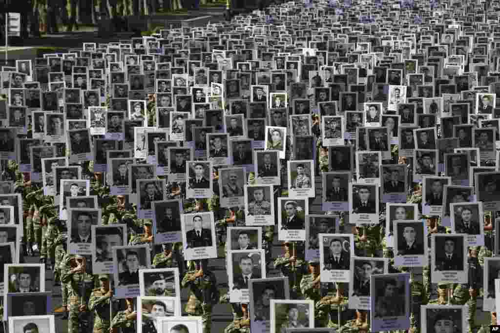 Azerbaijan&#39;s Army soldiers carry portraits of the soldiers killed during the fighting over Nagorno-Karabakh in 2020, during a memorial event in Baku, Azerbaijan.
