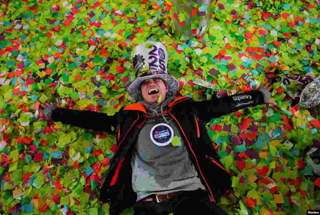 A man reacts while lying on top of confetti after the ball drop at Times Square during New Year's celebrations in New York City.