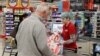 A cashier works behind a protective plexiglass shield at a supermarket in Sydney, Australia, Oct. 27, 2020.