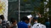 FILE - Migrants and refugees wait in a queue for the doctor at the Moria refugee camp on the northeastern Aegean island of Lesbos, Greece, Sept. 25, 2019. 