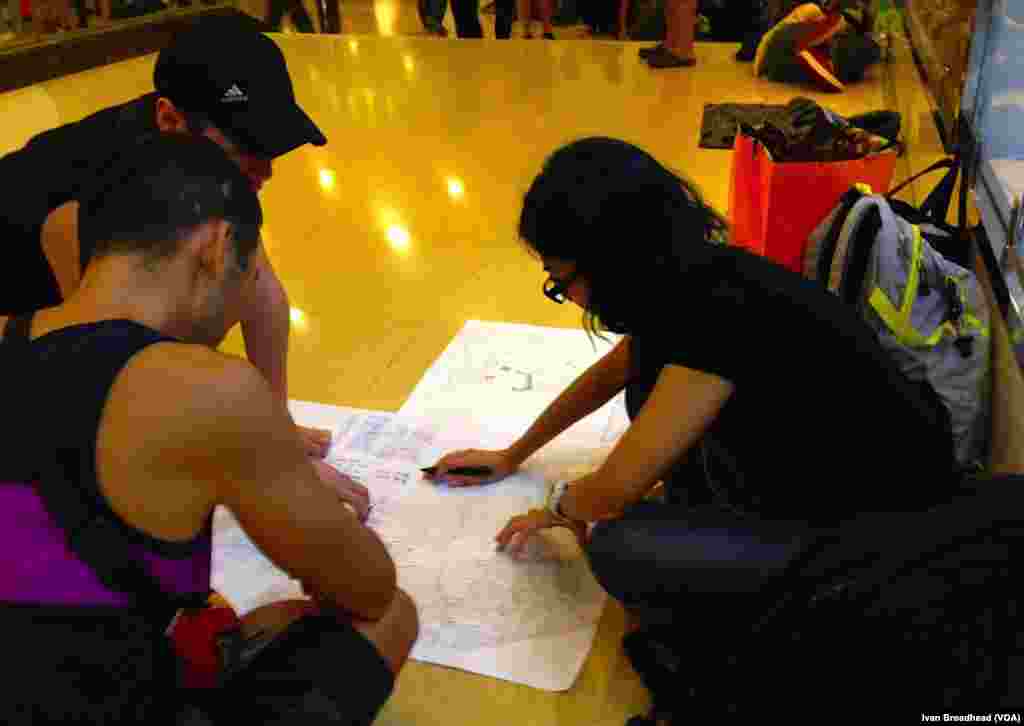 Di dalam stasiun metro Admiralty, pusat transportasi utama untuk kampanye pendudukan, tiga remaja anggota gerakan "Occupy Central" membahas peta evakuasi untuk merencanakan strategi keluar bagi puluhan ribu pemrotes yang tetap ada di tempat, kalau-kalau serangan polisi dapat kembali menyebabkan orang terinjak-injak (5/10).