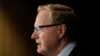 FILE - Reserve Bank Gov. Philip Lowe outlines measures the bank will take to support an economy rocked by international travel restrictions, bans on large public gatherings and escalating unemployment, in Sydney, March 19, 2020.