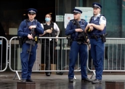 Police stand outside Christchurch High Court as family and survivors from the March 2019 Christchurch mosque shootings arrive for the sentencing of 29-year-old Australian Brenton Harrison Tarrant, in Christchurch, New Zealand, Aug. 24, 2020.