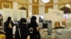 FILE - Saudi women wear the mandatory abaya, or loose-fitting gown, over their clothes