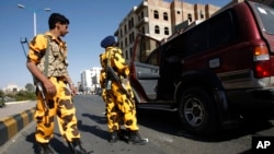 Houthi Shiite Yemenis wearing police uniforms check a vehicle at a street ahead of a tribal meeting held by Houthi Shiite rebels in Sanaa, Yemen, Oct. 31, 2014.