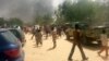 FILE - People look at smoke rising after suspected Boko Haram Islamists attack a military base in the northeast Nigerian city of Maiduguri. 