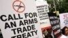 FILE - Activists campaigning for a global arms trade treaty hold placards during a protest in New Delhi, India.