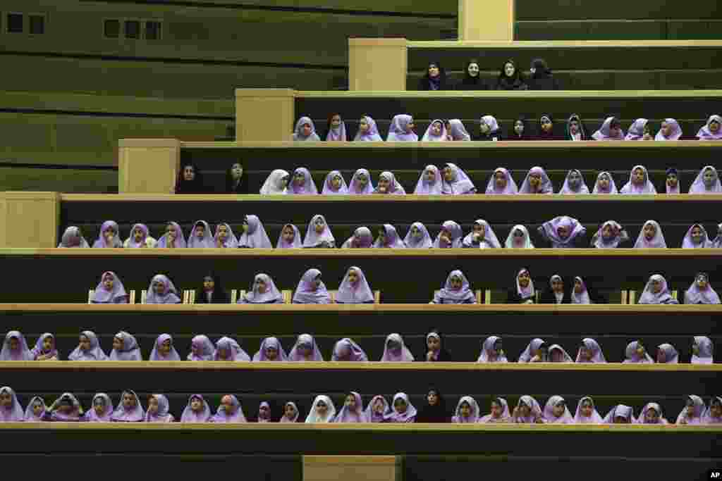 Iranian schoolgirls follow debates of lawmakers in an open session of the outgoing parliament in Tehran.