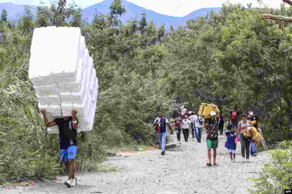 People cross from San Antonio del Tachira in Venezuela to Cucuta in Colombia through &quot;trochas&quot; -illegal trails- near the Simon Bolivar international bridge, Oct. 5, 2021.