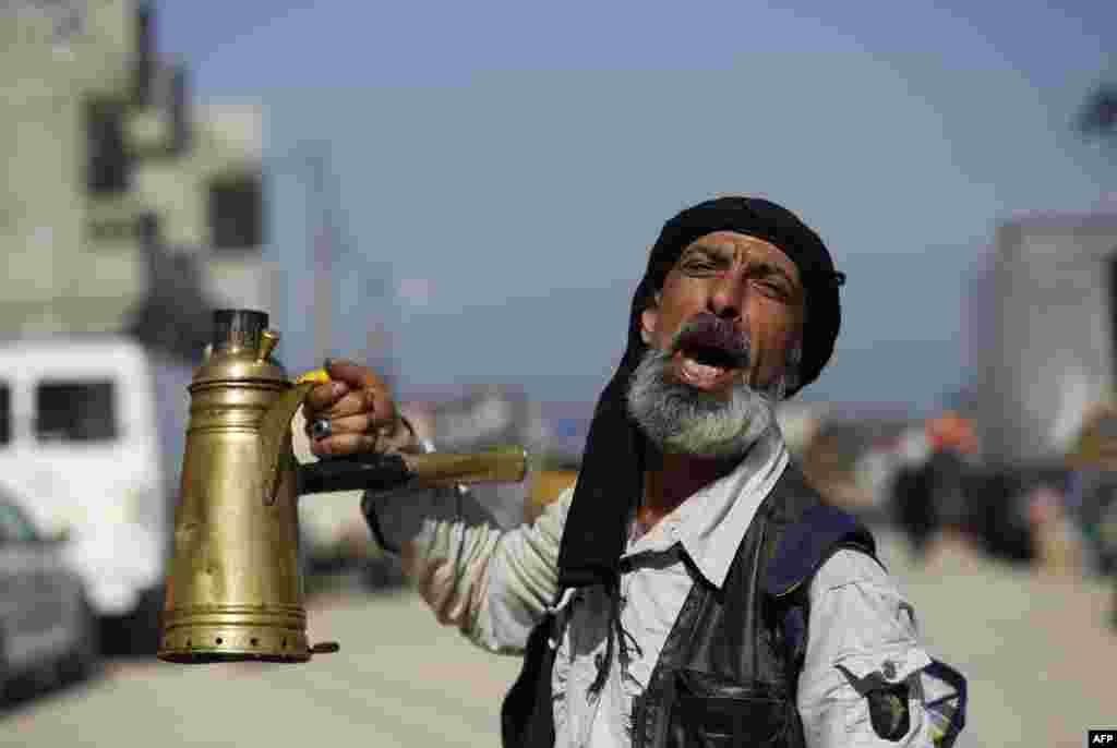 A Palestinian tea vendor calls out to clients at the weekly flea market in the in the Central Gaza Strip city of Nusseirat.