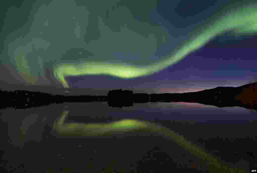 &#39;Aurora Borealis&#39; atau pancaran cahaya berkilauan pada lapisan ionosfer&nbsp;menghiasi langit di desa Erikslund, Vaesternorrland, Swedia.