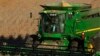 FILE - A farmer uses a combine to harvest his soybean field Oct. 21, 2014, in Loami, Ill.