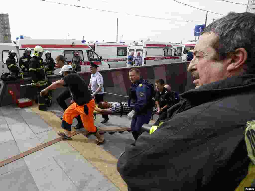 Members of emergency services carry an injured passenger outside a metro station following an accident on the subway, in Moscow, July 15, 2014.