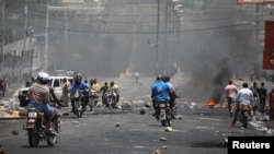 Haitians pass through a barricade on a street in Port-au-Prince, Haiti, July 8, 2018.
