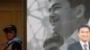 A protester stands near a portrait of former Thai Prime Minister Abhisit Vejjajiva at the Democrat Party headquarters during a rally in central Bangkok on November 1, 2013. 