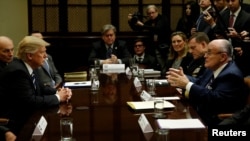 U.S. President Donald Trump listens to former New York City Mayor Rudy Giuliani during a meeting with cybersecurity experts in the Roosevelt Room of the White House in Washington, Jan. 31, 2017.