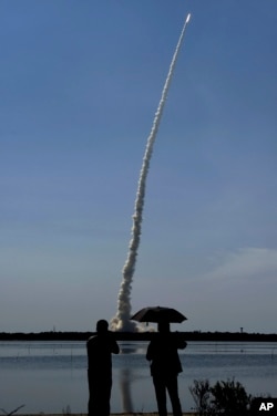 22일 인도 우주연구 기구(ISRO)가 인공위성 20개를 실은 로켓을 발사하는 장면을 관계자들이 지켜보고 있다.