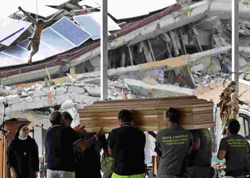 Petugas kota Amatrice, Italia tengah menyiapkan peti jenazah untuk upacara penguburan para korban gempa di sana.
