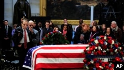 Former Sen. Bob Dole salutes the flag-draped casket containing the remains of former President George H.W. Bush as he lies in state at the U.S. Capitol in Washington, Dec. 4, 2018.