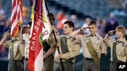 FILE - A color guard of Boy Scouts salute during the national anthem before a baseball game in Seattle, May 25, 2014.