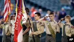 A color guard of Boy Scouts from the Chief Seattle Council salute during the national anthem before a baseball game between the Seattle Mariners and Houston Astros in Seattle, May 25, 2014.