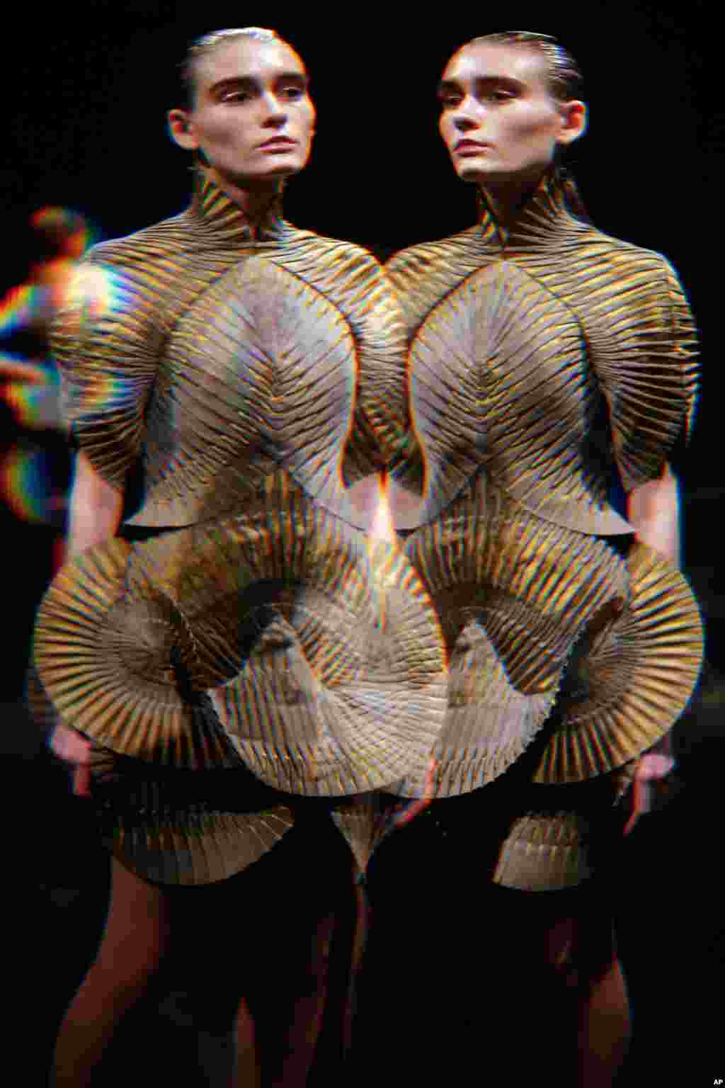 A model, seen through distorting glass, wears a creation for Iris Van Herpen&#39;s Fall-Winter 2016-2017 ready to wear fashion collection presented in Paris, France.