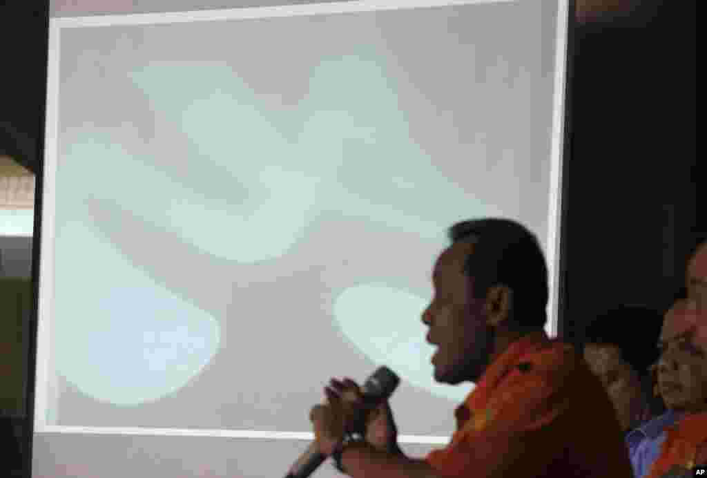 Chief of National Search And Rescue Agency (BASARNAS) F. Henry Bambang Soelistyo shows an underwater photo of AirAsia Flight 8501 wreckage found by divers in the Java Sea, during a press conference in Jakarta, Indonesia, Jan. 7, 2015.