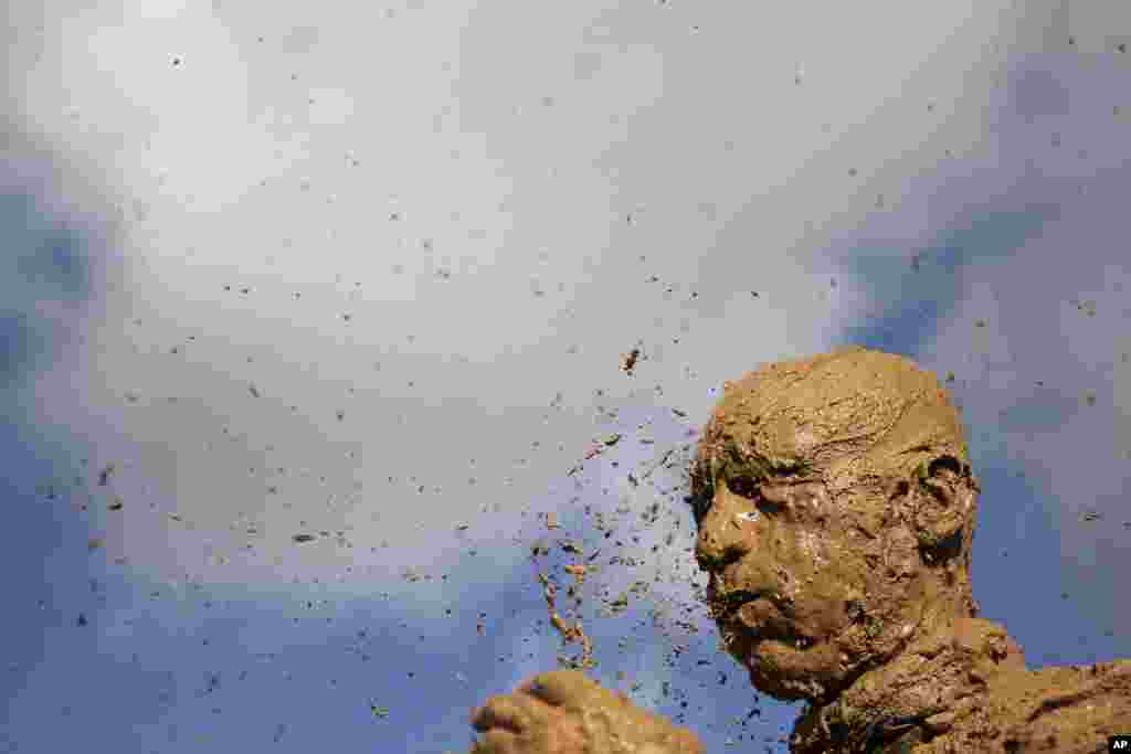 An Iranian mourner covers his head with mud during Ashura rituals, marking the death anniversary of Imam Hussein, the grandson of Islam's Prophet Muhammad, at the city of Bijar, west of the capital Tehran.