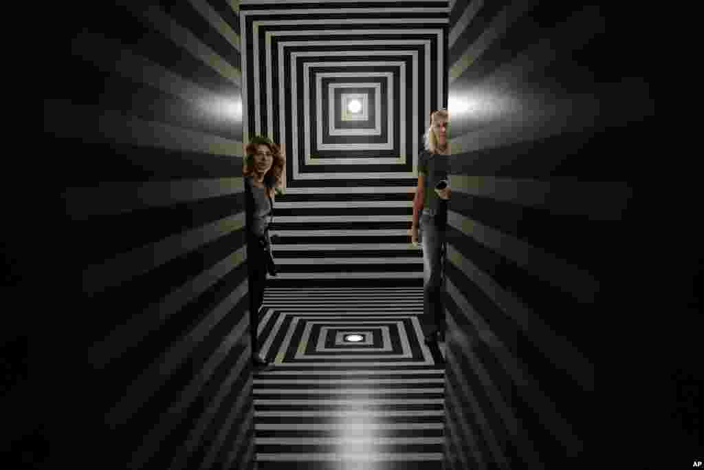 Visitors stand inside the installation 'Le mie prigioni' (My Jails), by architect Alessandro Mendini, part of the 'Fuori Salone' exhibitions during the Design Week, in Milan, Italy.
