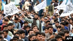 Afghan fans wave Taliban flags as they watch a live broadcast of the ICC men's Twenty20 World Cup 2024 semi-final cricket match between Afghanistan and South Africa, on a big screen at Kabul International cricket stadium in Kabul on June 27, 2024.