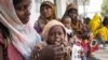 FILE - A woman feeds her child at a clinic in a rural village in Afar, Ethiopia, Jan. 26, 2016.