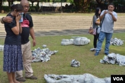 Slain reporter's wife Edita Tiamzon and National Union of Journalists of the Philippines Director Nonoy Espina circle an exhibit depicting fallen victims of the Maguindanao massacre, in Quezon City, Nov. 23, 2014. (S. Orendain/VOA)