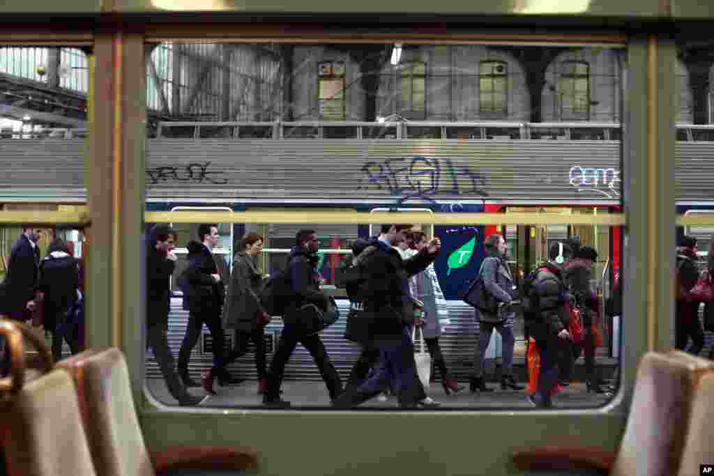 Commuters walk on a platform to catch a train at the Gare de l&#39;Est train station in Paris. France&#39;s six rail unions have issued a joint call for a one-day strike that is set to disrupt local and national train traffic, but not international lines.
