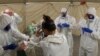 In this photo provided by the New South Wales Police, investigators in protective gear prepare to board the Ruby Princess cruise ship in Wollongong, Australia, April 8, 2020. 