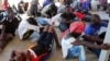 FILE - Migrants are seen after being rescued by Libyan coast guard in Khoms, Libya, Aug. 27, 2019.