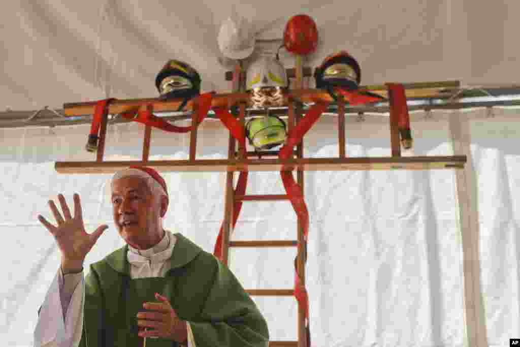 Uskup Giovanni D&#39;Ercole memberikan khutbah Misa di sebuah tenda yang dihiasi &quot;kayu salib&quot; dari tangga, pasca gempa di kota Arquata Del Tronto, dekat Amatrice, Italia tengah.