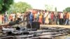 FILE - Suspected fighters are paraded before the media by Burundian police near a recovered cache of weapons after clashes in the capital Bujumbura, Burundi, Dec. 12, 2015.
