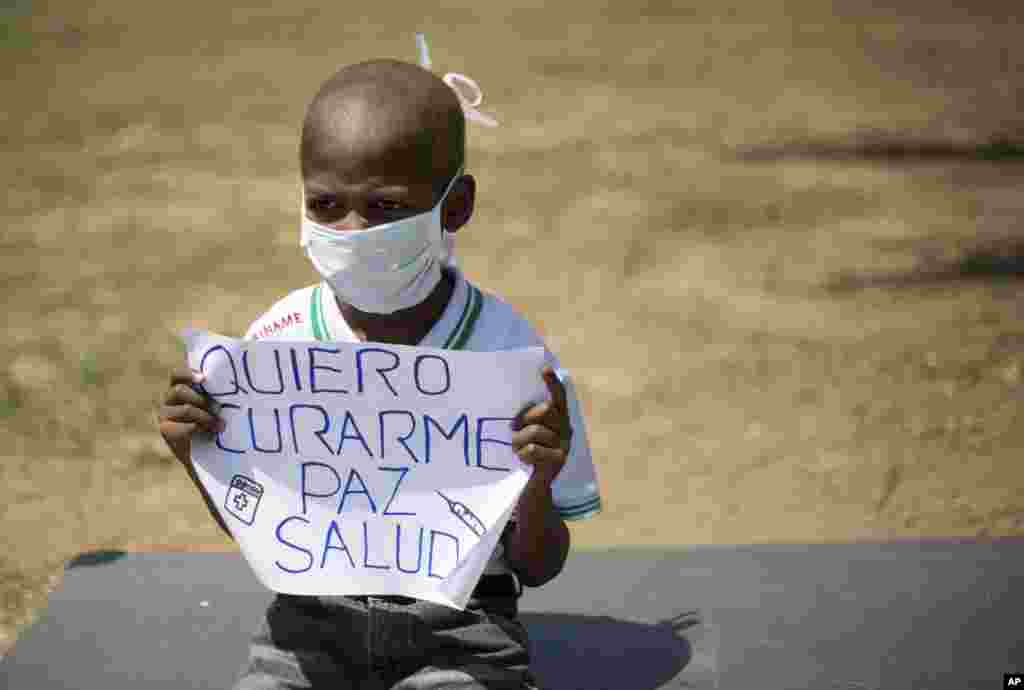 Oliver Sanchez, 8, holds a sign that reads in Spanish &quot;I want to heal, peace, health&quot; during a protest against the shortage of medicines and medical supplies, in Caracas, Venezuela. Oliver has Non-Hodgkin&#39;s lymphoma and his treatment was stopped a month ago because he can&#39;t find the medicine for his treatment.