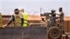 Les commandos de la force française Barkhane montent une mitrailleuse sur une camionnette camouflée alors que des travailleurs maliens passent avant de partir en mission depuis leur base de Gao, au Mali, le undi 7 juin 2021.