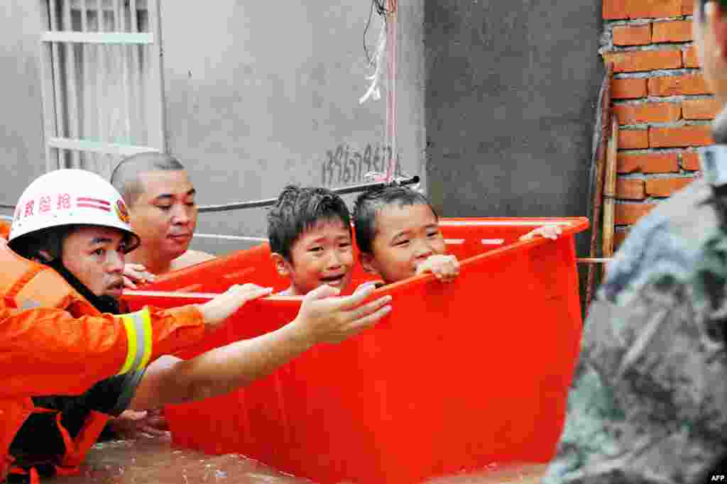 Rescuers evacuate flood-affected children in Ningde, eastern China&#39;s Fujian province. Typhoon Megi smashed into the Chinese mainland, killing one person, after leaving a trail of destruction and four people dead in Taiwan.