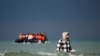 Seorang migran berjalan menuju perahu karet dalam upaya menyeberangi Selat Inggris untuk mencapai Inggris dari wilayah Wimereux, Prancis, pada 4 September 2024. (Foto: Reuters/Benoit Tessier)