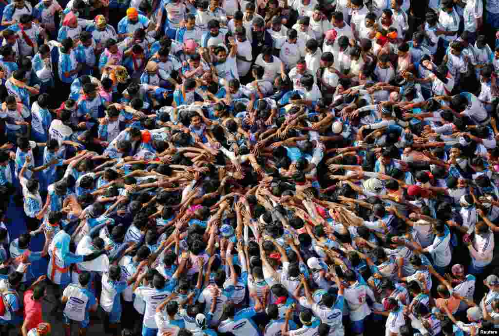 Warga Hindu membentuk piramida manusia untuk merayakan festival Janmashtami, memperingati kelahiran Dewa Krishna di Mumbai, India.
